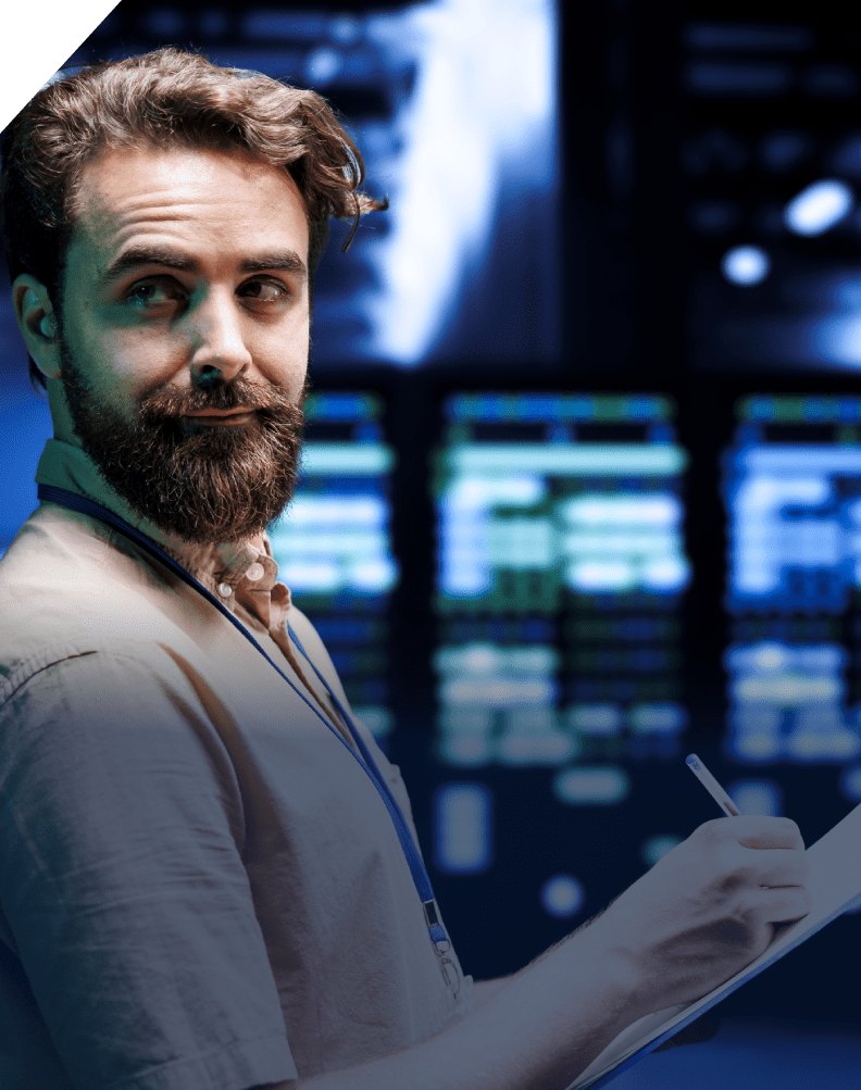 A man holding papers in front of monitors.