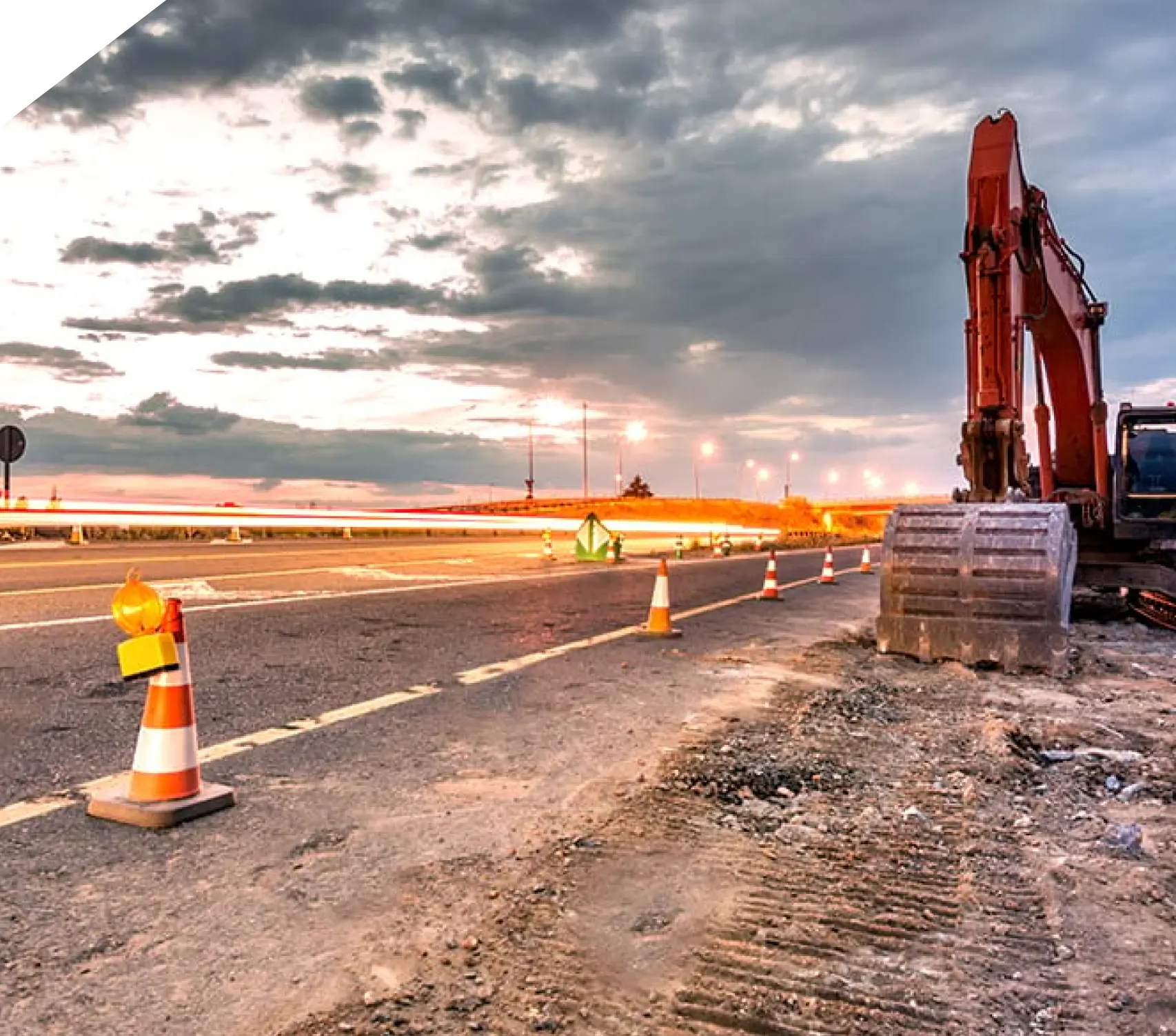 A construction site with a road and some orange cones.